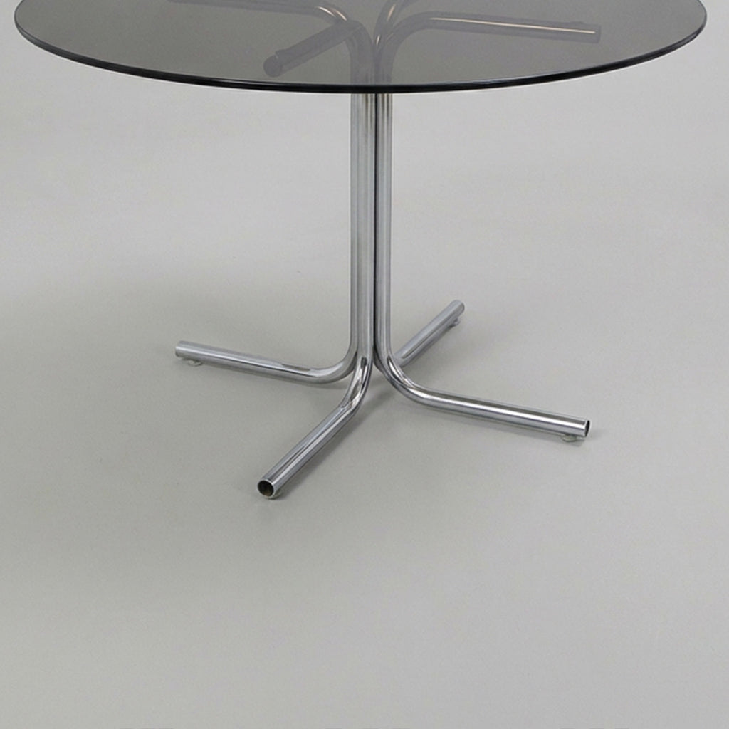 Dining table with tubular base and smoked glass top