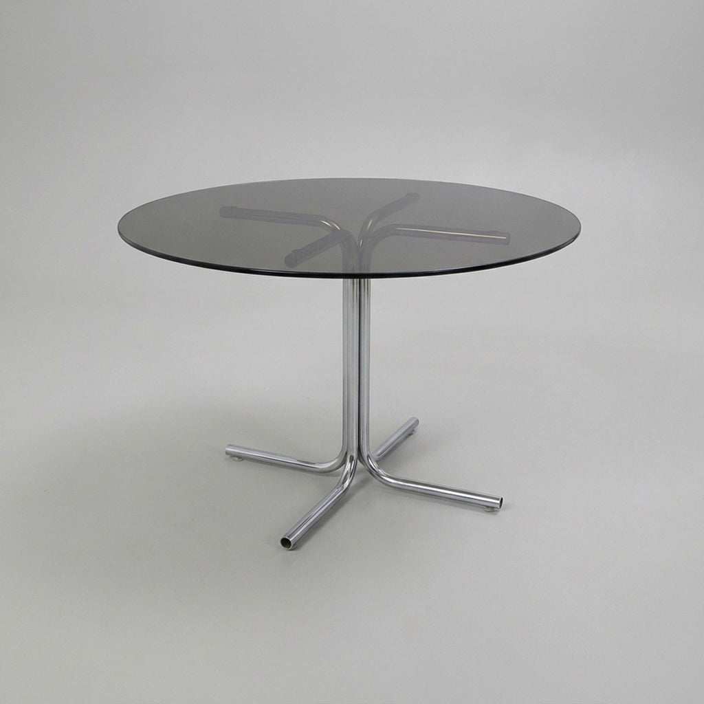 Dining table with tubular base and smoked glass top