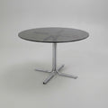 Dining table with tubular base and smoked glass top